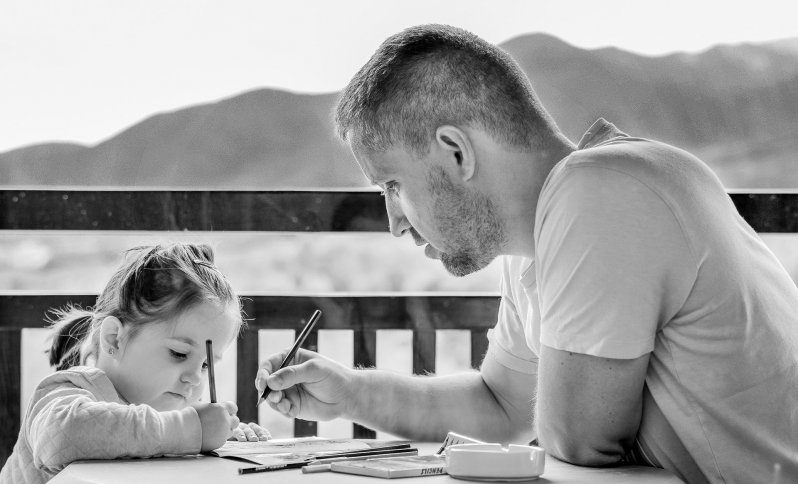 Portrét dcéry s otcom, ktorý jej pomáha kresliť obrázok.