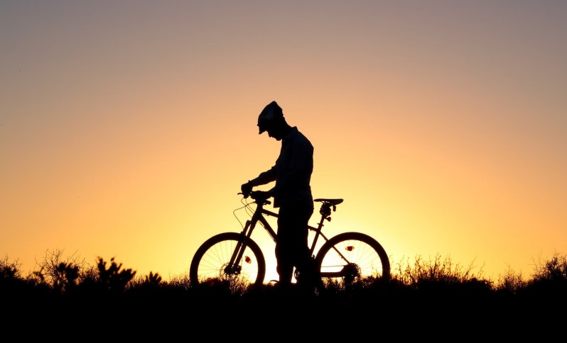 Fotografia cyklistu pri západe slnka.